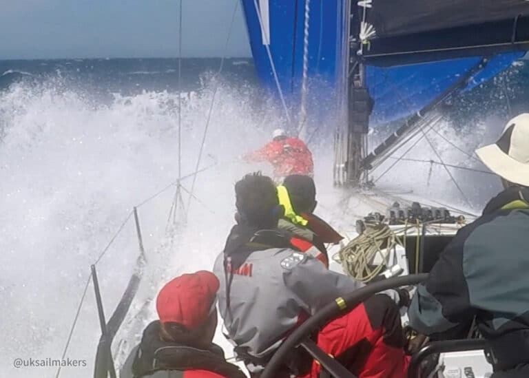 Heavy Weather Crew Training UK Sailmakers - wave crashing over the bow of a boat flying spinnaker