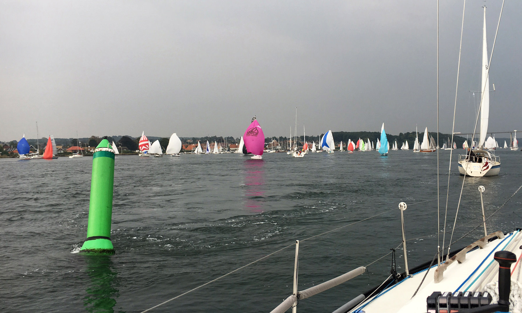 DOGMATIC approaching the starting line as the slower boats, that have already started, attempt to make progress against the strong current off of SVENDBORG.