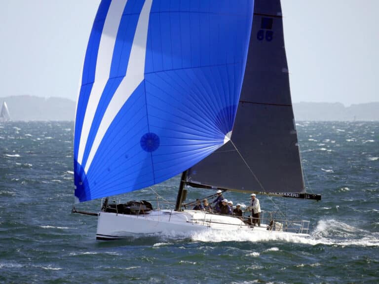 King 40 Checkmate, sailing downwind in heavy breeze with a blue asymmetrical spinnaker.
